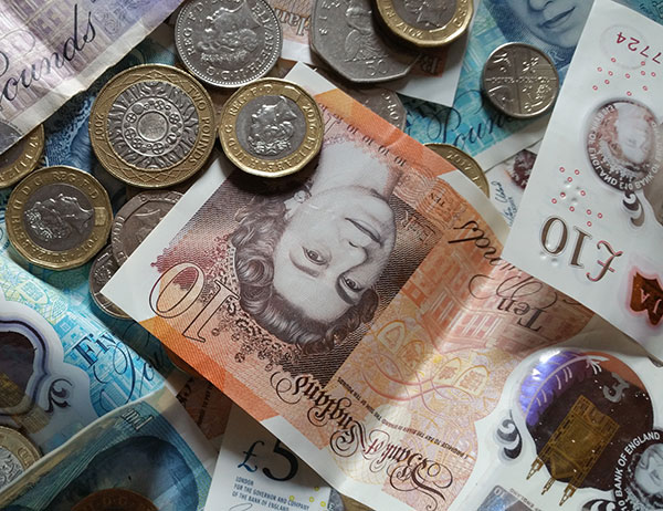 Close-up of various British currency notes and coins