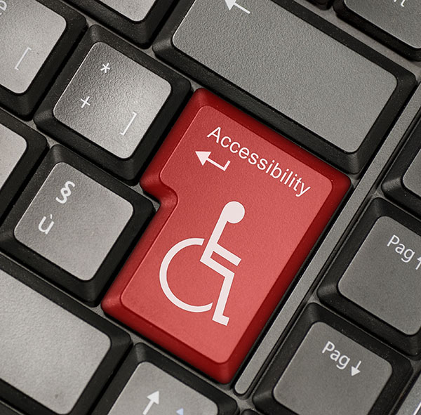 Close-up of a keyboard with a red 'Accessibility' key featuring the wheelchair symbol.