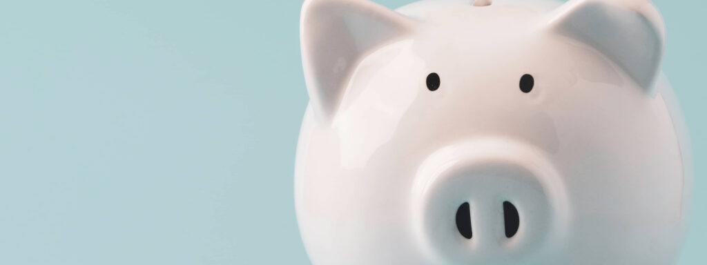 White ceramic piggy bank on a soft blue background