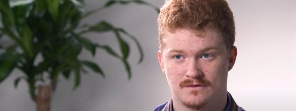 Young man with ginger hair and a sincere expression indoors