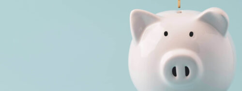 White ceramic piggy bank on a soft blue background