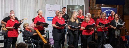 Choir members of various ages and abilities performing at an event