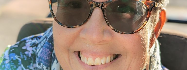 Close-up of a smiling person wearing sunglasses