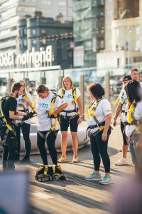 Event participants in white T-shirts and yellow harnesses getting ready for an outdoor activity.