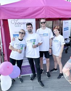 A group of four smiling individuals in white t-shirts at the Independent Lives Drop 360 event