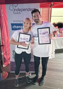 Katy and Danny holding certificates at Independent Lives' Drop 360 event.