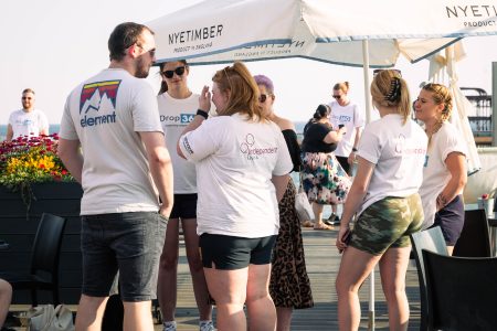 Volunteers from Independent Lives engaged in conversation at an outdoor charity event.