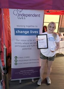 Molly holding her certificate and a mug after participating in the Drop 360 charity event for Independent Lives.