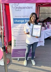 Nuwani proudly displaying her certificate and mug at an Independent Lives charity event.