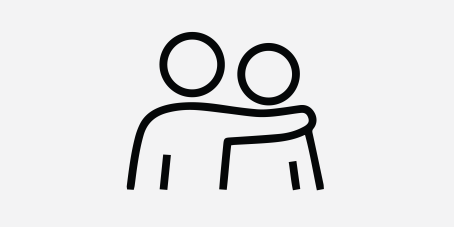 A simple black and white icon showing two abstract figures with one figure placing their arm around the other in a supportive gesture.
