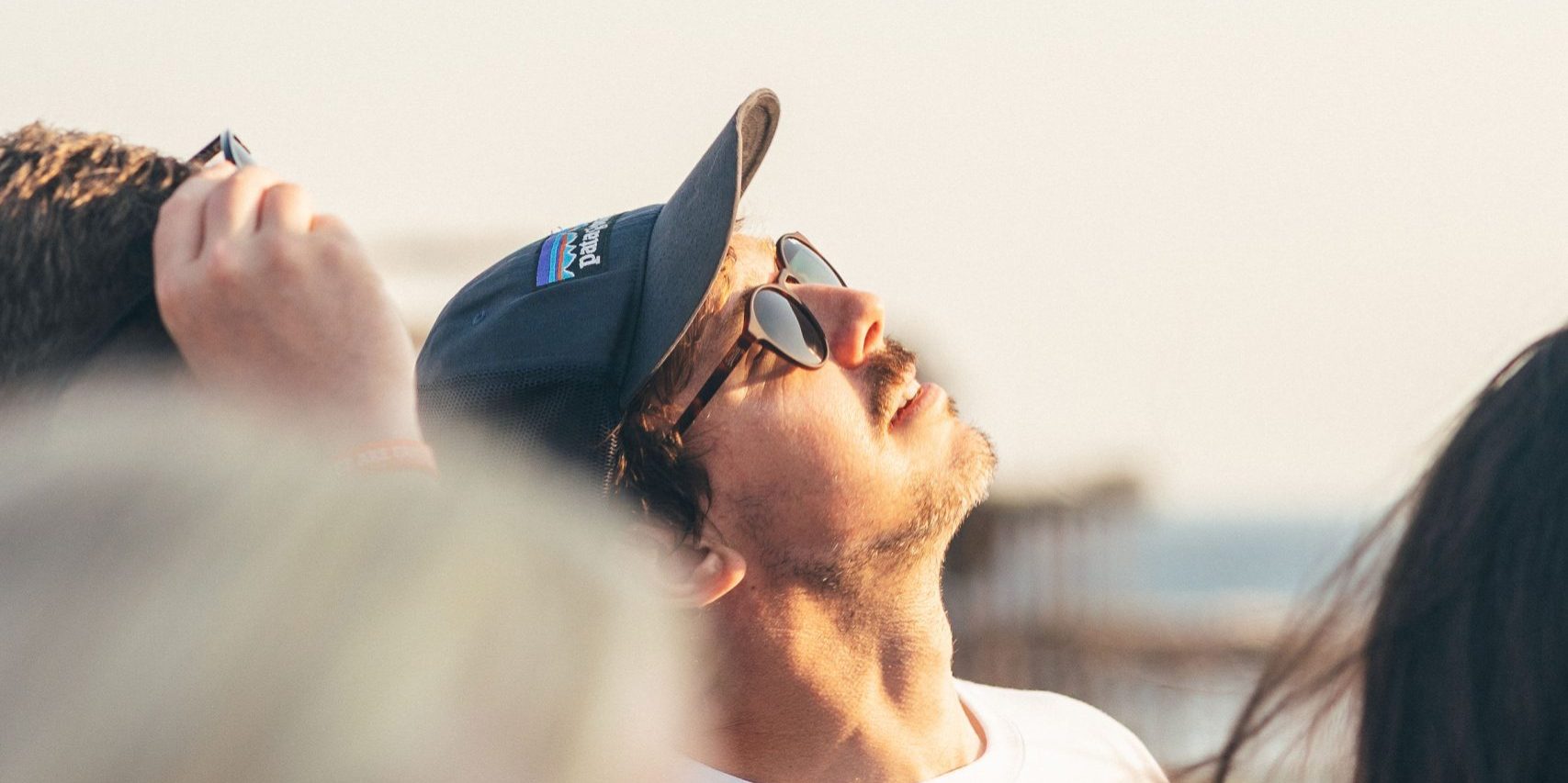 A man in a baseball cap looking upwards, wearing a t-shirt with the "Drop 360 Supporting Independent Lives" logo.