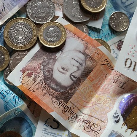 Close-up of various British currency notes and coins