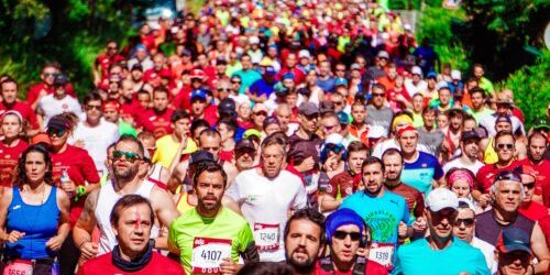 Crowded marathon event with runners in colourful attire.